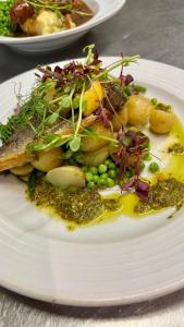 a white plate with a salad with fish and vegetables at Jack & Jill Inn Pub in Hassocks