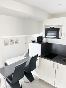 a white kitchen with a table and a microwave at Chablis SPA Premier Cru in Chablis