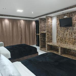a hotel room with two beds and a flat screen tv at Hotel Gool De Guerron in Quito