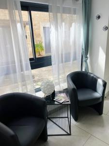 two chairs and a table in front of a window at Chablis SPA Premier Cru in Chablis