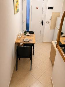 a table and chairs in a room with a kitchen at Oxygen Riva del Garda Monolocale con Balcone e Bike Room in Riva del Garda