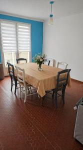 a wooden table with chairs and a vase of flowers on it at Séjour bercé par la Mer in Jard-sur-Mer +11 photos