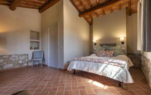a bedroom with a bed and a chair in a room at Agriturismo La Vecchia Quercia in Montemerano
