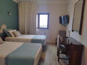 a hotel room with two beds and a desk at Hotel Areias Claras in Viana do Castelo +30 photos
