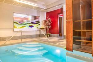 a swimming pool in a room with a painting on the wall at Hotel Zemaites in Vilnius