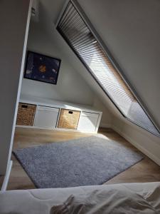 a attic room with a large window and a rug at Lüdde Stuv am Meer in Husum