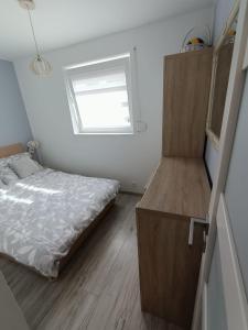 a small bedroom with a bed and a window at MoRze MielNo in Mielno