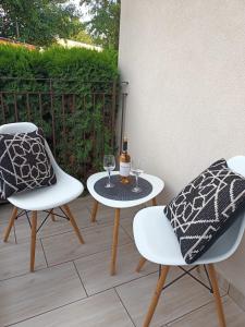 a patio with two chairs and a table with wine glasses at MoRze MielNo in Mielno