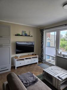 a living room with a large flat screen tv at Lüdde Stuv am Meer in Husum