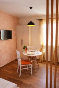 a dining room with a white table and chairs at Stone Garden Residence in Budva
