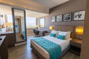 a hotel room with a large bed and a desk at Hotel Terrado Rancagua in Rancagua