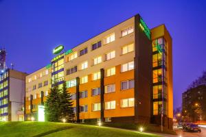 un edificio con un árbol delante de él en Hotel Zemaites en Vilna
