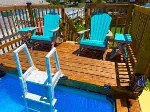 three chairs sitting on a deck next to a swimming pool at Sunset by the Sea 3054 in Fort Myers Beach