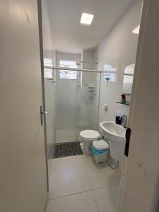 a bathroom with a shower and a toilet and a sink at Quitinete Centro de Guarapari. in Guarapari +34 photos