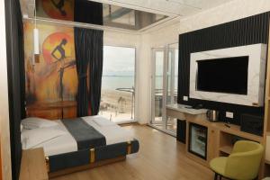 a bedroom with a bed with a view of the ocean at Vila One Beach Hotel in Durrës