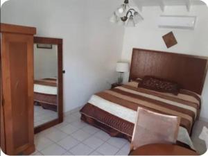 a bedroom with a large bed and a mirror at Chez Lilly in Oranjestad +22 photos