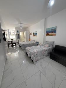 a living room with two beds and a couch at Quitinete Centro de Guarapari. in Guarapari
