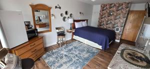a small bedroom with a bed and a mirror at Myrtle Lane Inn in Coquille
