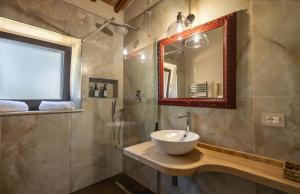 a bathroom with a sink and a mirror at Agriturismo La Vecchia Quercia in Montemerano +74 photos