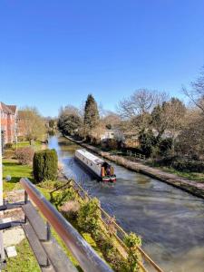 a boat traveling down a river with a bridge at 2 Bedroom Apartment in Exhall