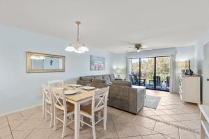 a living room with a table and a couch at Sand Between Stays in Orange Beach
