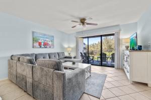 a living room with a couch and a ceiling fan at Sand Between Stays in Orange Beach