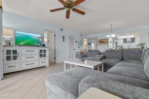 a living room with a couch and a flat screen tv at Sand Between Stays in Orange Beach