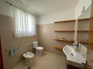 a bathroom with a toilet and a bidet and a sink at Kasa n'areia, Praia Estoril in Sal Rei +14 photos