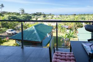 a balcony with a view of a house at ARIIMOE Hava'e in Teahupoo +15 photos