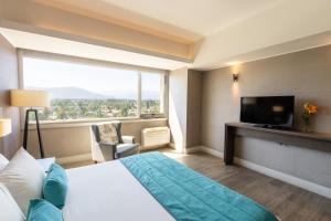 a hotel room with a bed and a large window at Hotel Terrado Rancagua in Rancagua