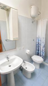 a bathroom with a sink and a toilet and a mirror at Cala Dei Saraceni in Peschici