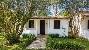 a small white house with trees in front of it at Cala Dei Saraceni in Peschici +3 photos