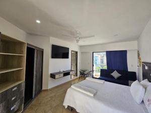 ein Schlafzimmer mit einem großen Bett und einem Fernseher in der Unterkunft Casa Xtao Hotel in Santa Cruz Huatulco