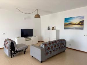 a living room with a couch and a tv at Kasa n'areia, Praia Estoril in Sal Rei