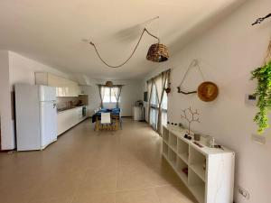 a kitchen with a white refrigerator and a table at Kasa n'areia, Praia Estoril in Sal Rei