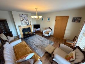 a living room with white furniture and a fireplace at 10 Mill Square in Portstewart