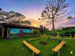 a group of benches in the grass in front of a building at Finca Hotel La Herencia Cafetera in Montenegro