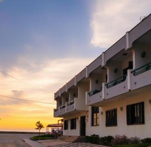 a building with a sunset in the background at Hotel Areias Claras in Viana do Castelo