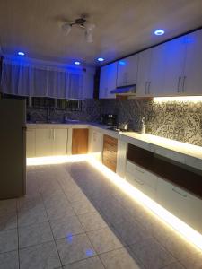 a kitchen with white cabinets and blue lights at La Casa del Centro in Quesada
