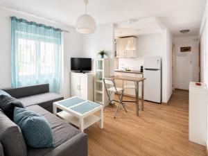 a living room with a couch and a table and a kitchen at Flores in Málaga