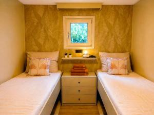 two beds in a small room with a window at Boshuisje Dille te Veluwe in Putten +25 photos