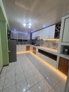 a large kitchen with white cabinets and a refrigerator at La Casa del Centro in Quesada