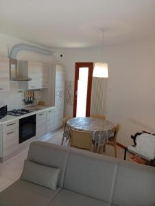 a living room with a table and a kitchen at Casa Rotary in Lugo