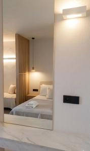 a mirror reflection of a bedroom with a bed at Pnoé Sea View Suites in Limenas +38 photos