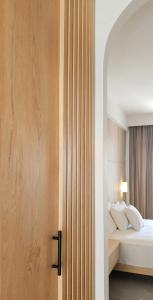 a bedroom with a bed and a wooden door at Pnoé Sea View Suites in Limenas