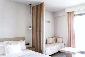 a living room with a couch and a bed at Pnoé Sea View Suites in Limenas