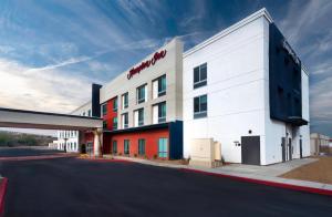 a white building with a red sign on the side of it at Hampton Inn Needles Colorado River in Needles