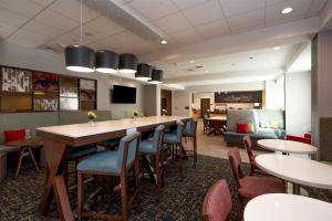 a restaurant with tables and chairs and a bar at Hampton Inn Needles Colorado River in Needles
