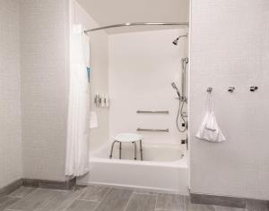 a white bathroom with a shower and a stool at Hampton Inn Needles Colorado River in Needles +24 photos