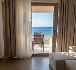 a bedroom with a view of the ocean from a door at Pnoé Sea View Suites in Limenas